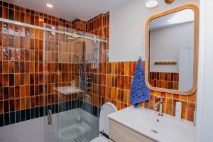 Modern shower system with rain head and handheld on rust toned glossy wall tile1