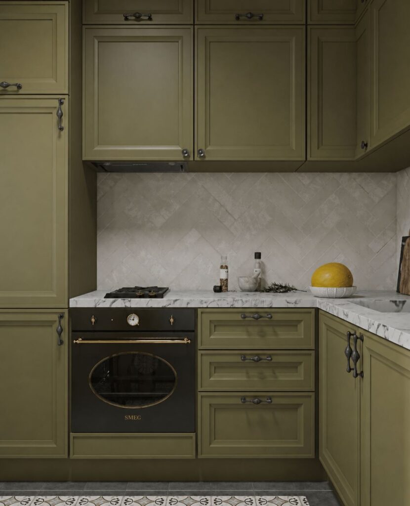 Olive green kitchen renovation with marble countertop, herringbone backsplash, black SMEG oven, and yellow melon in a white bowl