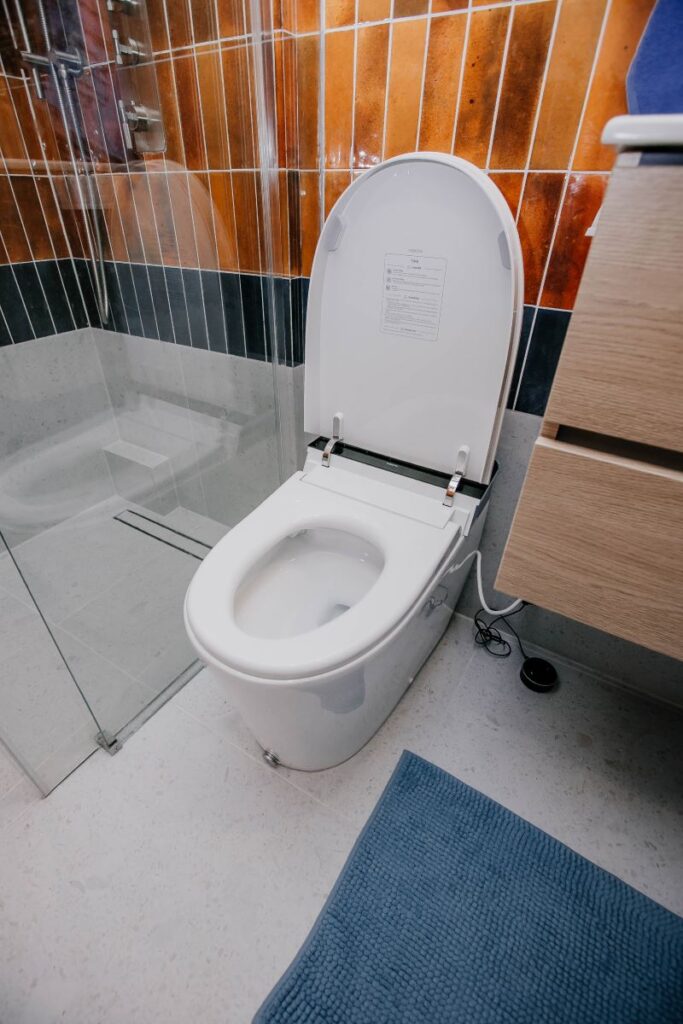 Smart toilet beside floating vanity and curbless shower in modern bathroom remodel