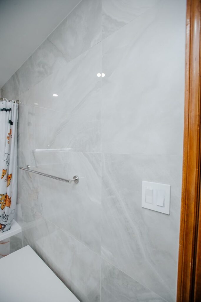 Polished chrome towel bar on a pearl marble wall in North York