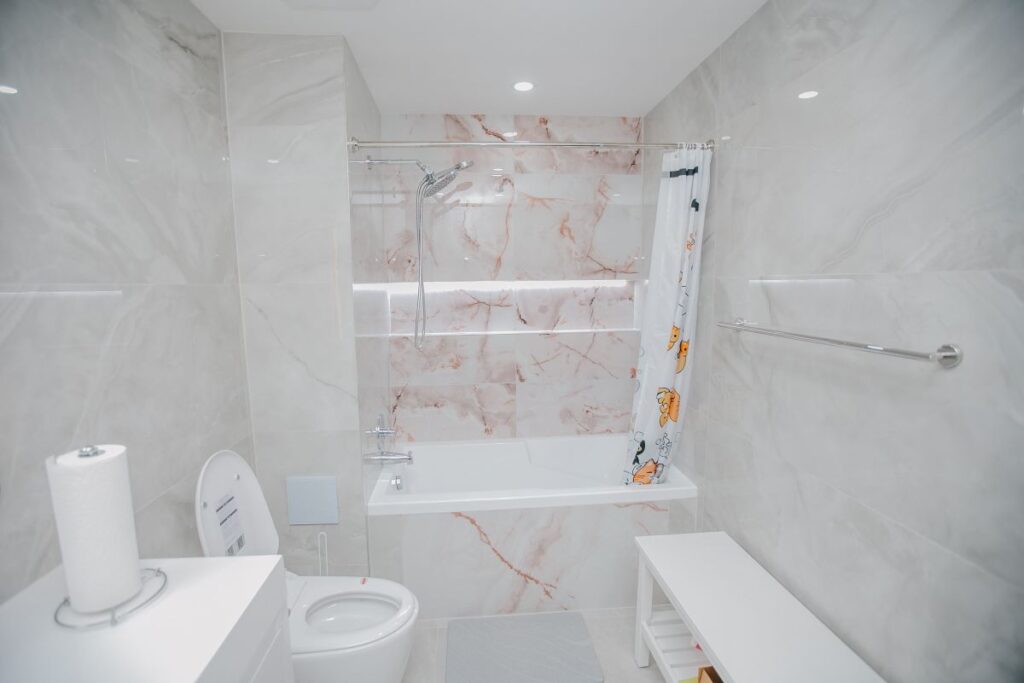 Renovated bathroom with smart toilet, floating vanity and tiled bathtub