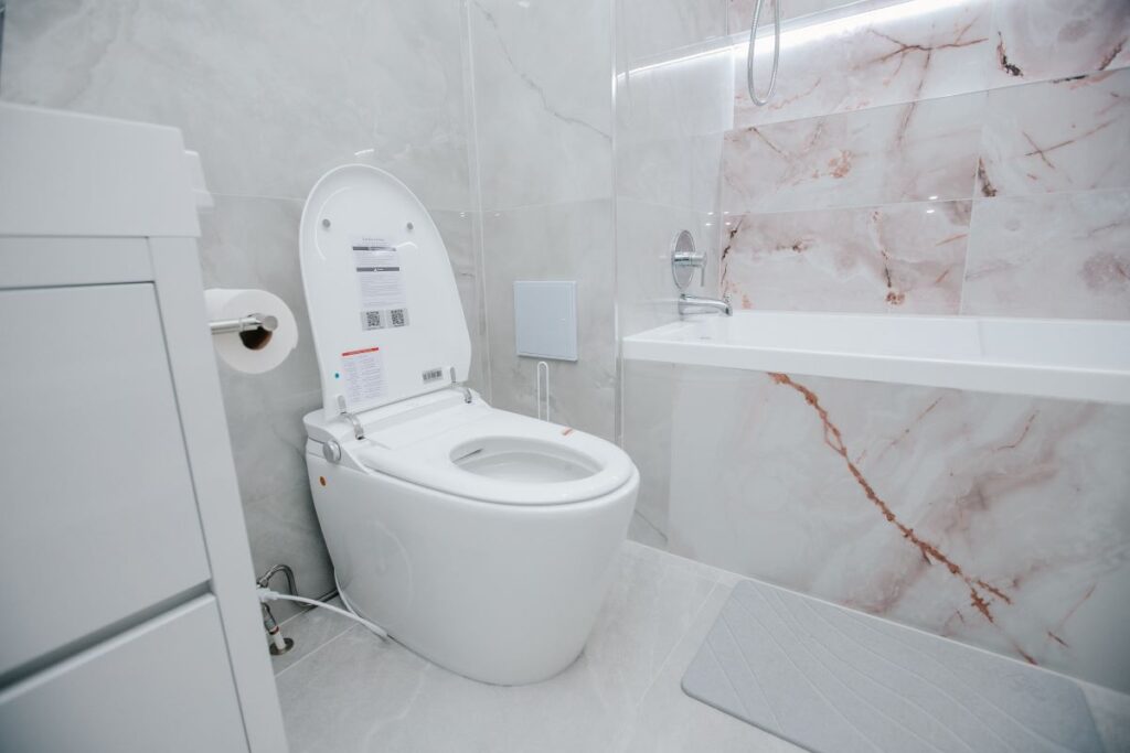 Royal Bath smart toilet beside a blush onyx bathtub wall in North York