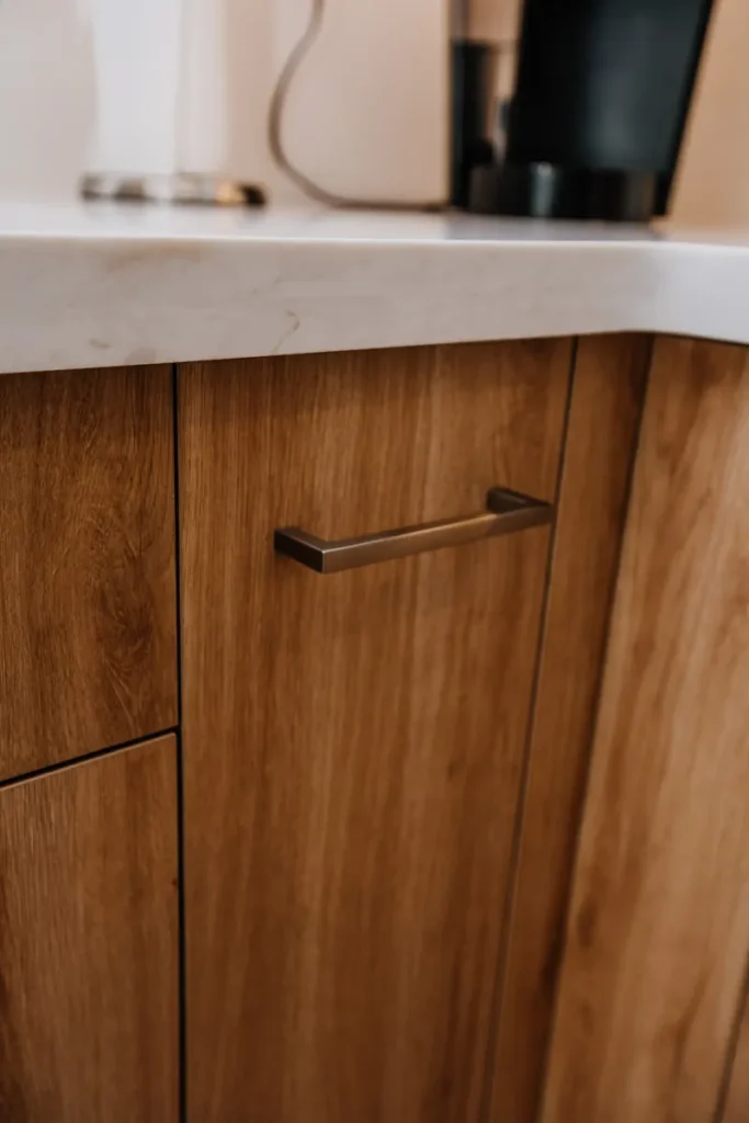 brushed nickel handle on wood grain laminate cabinet door kitchen renovation detail in mississauga by magic reno