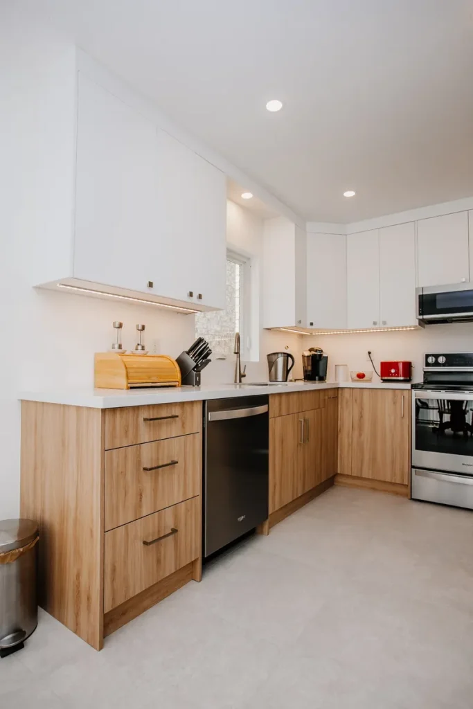 l shaped kitchen after full renovation in mississauga with two tone cabinetry and large format tile flooring