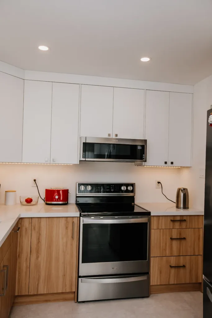 stove wall with ceiling height white cabinets and low profile microwave after bulkhead removal in mississauga kitchen