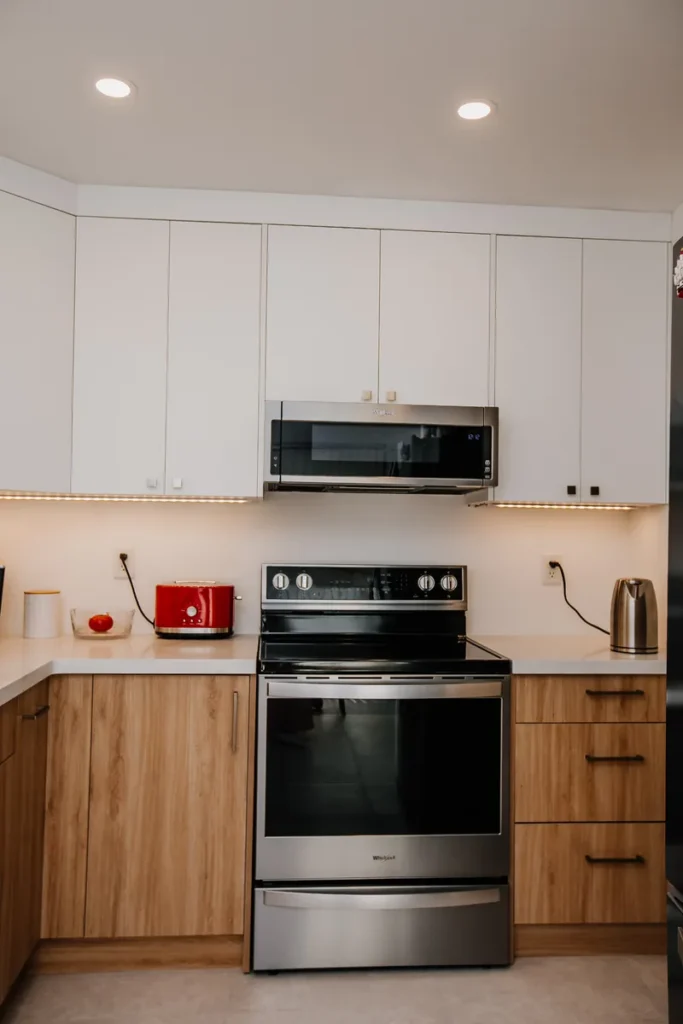 whirlpool electric range and over the range microwave between flat panel cabinets in remodelled mississauga kitchen