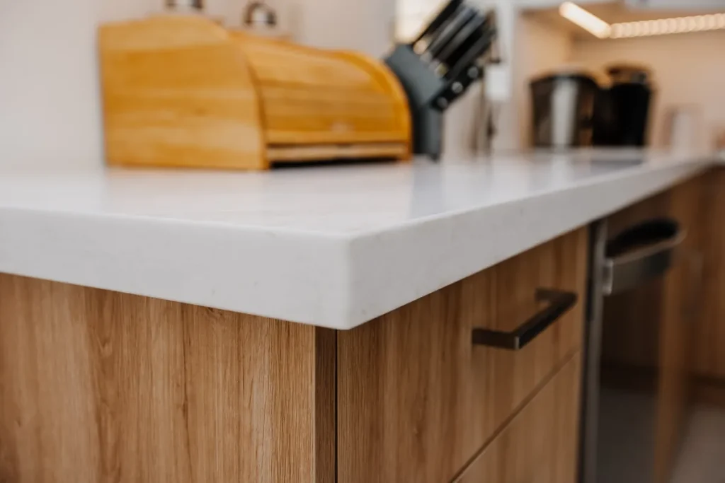 white quartz style countertop edge over wood grain base cabinets in completed mississauga kitchen renovation
