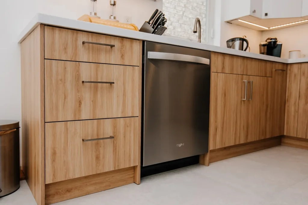 wood tone drawer bank and built in dishwasher along renovated kitchen run in mississauga home by magic reno